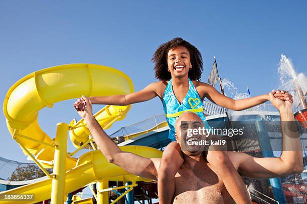 father and daughter in front of yellow water slide - waterpark stockfoto's en -beelden