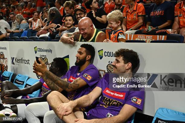 Jonah Bolden of the Kings takes a photo with some fans during the extended half time break during the round 10 NBL match between Cairns Taipans and...