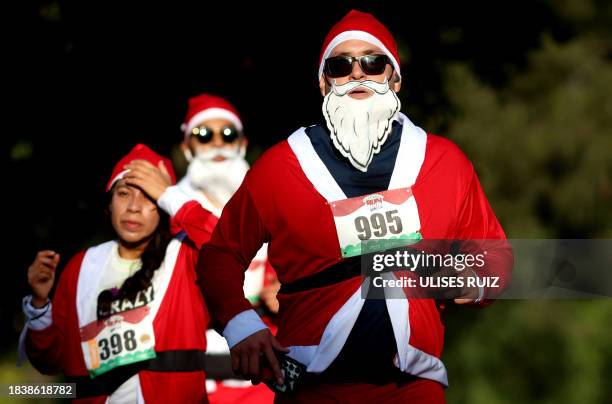 Runners dressed as Santa Claus take part in the annual "Run Santa Run" Christmas race in Zapopan, Mexico, on December 10, 2023.