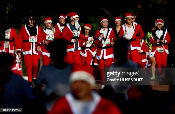 Runners dressed as Santa Claus take part in the annual "Run Santa Run" Christmas race in Zapopan, Mexico, on December 10, 2023.