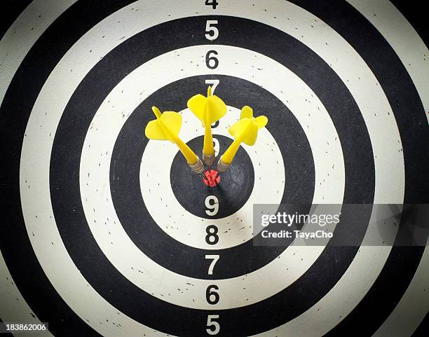 three yellow darts in the black and white dartboard bullseye - bullseye target stock pictures, royalty-free photos & images