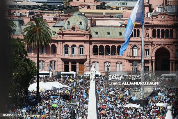 In this aerial view Argentina's new president Javier Milei waves at the crowd from a balcony of the Casa Rosada government palace during his...