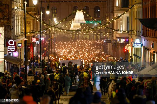 People walk with lights during a torchlight procession organized by The Norwegian Peace Council for the winner of the Nobel Peace Prize, Narges...