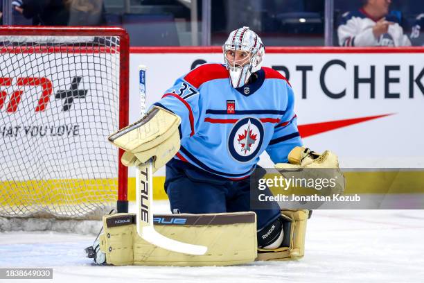 Goaltender Connor Hellebuyck of the Winnipeg Jets takes part in the pre-game warm up prior to NHL action against the Carolina Hurricanes at Canada...