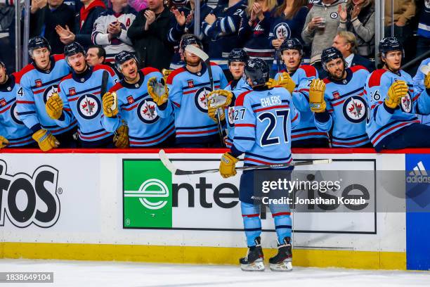 Nikolaj Ehlers of the Winnipeg Jets skates by the bench to celebrate his second period goal against the Carolina Hurricanes at Canada Life Centre on...