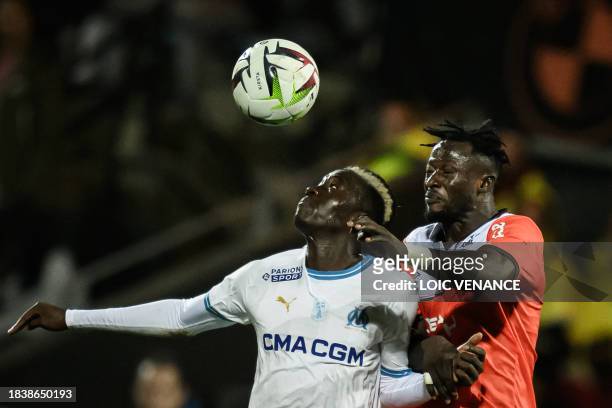 Marseille's French midfielder Pape Gueye fights for the ball with Lorient's Nigerian midfielder Bonke Innocent during the French L1 football match...
