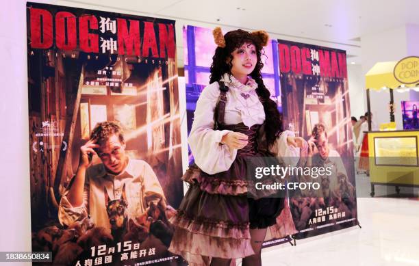 Fan in front of a poster for the new movie DogMan, directed by Luc Besson and starring Caleb Landry Jones, in Shanghai, China, December 10, 2023.