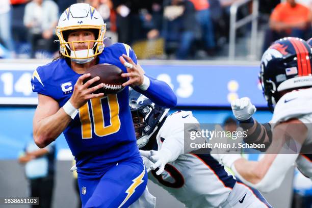 Inglewood, CA Los Angeles Chargers quarterback Justin Herbert runs with the ball while Denver Broncos linebacker Jonathon Cooper defends during the...