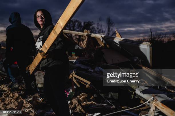 Resident lives a board to add to a pile in search of pets and belongings of a destroyed home in the aftermath of a tornado on December 10, 2023 in...