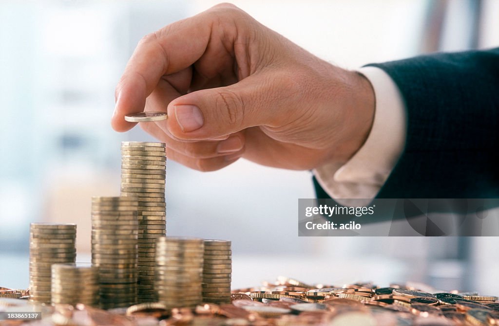 Empresario está apilado de monedas