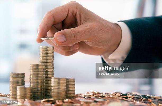 businessman is stacking coins - mid adult men stock pictures, royalty-free photos & images