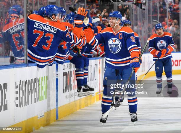 Connor McDavid of the Edmonton Oilers celebrates his third period goal against the New Jersey Devils with his teammates at the bench at Rogers Place...