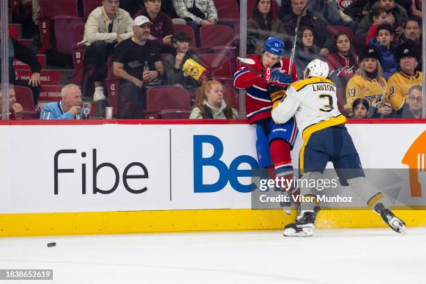 Jeremy Lauzon of the Nashville Predators checks Jake Evans of the Montreal Canadiens during the first period of the NHL regular season game at the...