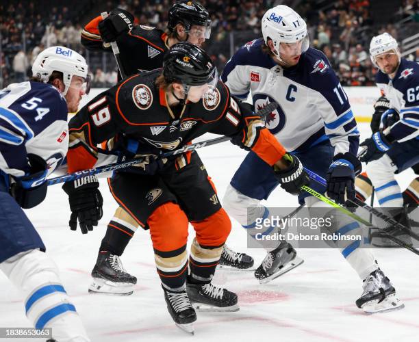 Dylan Samberg of the Winnipeg Jets, Troy Terry of the Anaheim Ducks and Adam Lowry of the Winnipeg Jets battle for position during the first period...