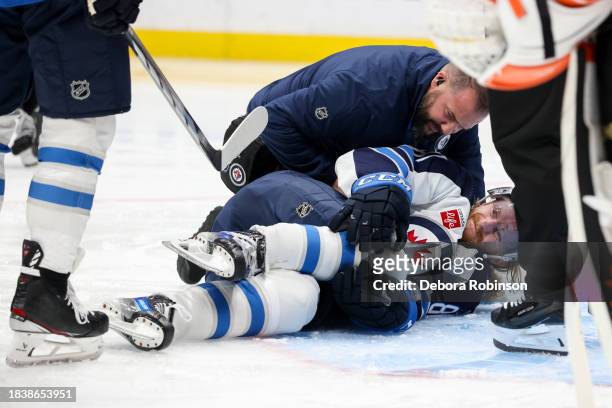 Kyle Connor of the Winnipeg Jets falls to the ground after an apparent injury during the second period against the Anaheim Ducks at Honda Center on...
