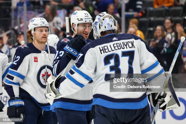 Gabriel Vilardi of the Winnipeg Jets and Connor Hellebuyck celebrate their victory against the Anaheim Ducks at Honda Center on December 10, 2023 in...
