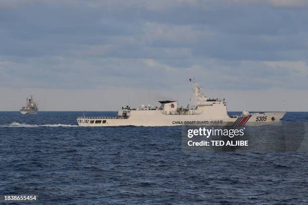 This photo taken on December 10, 2023 shows a Chinese coast guard ship shadowing a Philippine vessel loaded with provisions for Filipino fishermen...