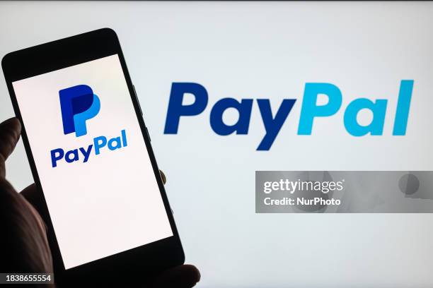 The PayPal online banking logo is being displayed on a smartphone with PayPal visible in the background, in this photo illustration, in Brussels,...
