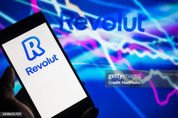 The logo of Revolut online banking is being displayed on a smartphone with the Revolut brand visible in the background, in this photo illustration,...