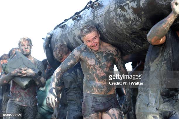 Tristyn Cook of the Blues carries an inflatable boat during an Auckland Blues mud run training session at Devonport Naval Base on December 08, 2023...