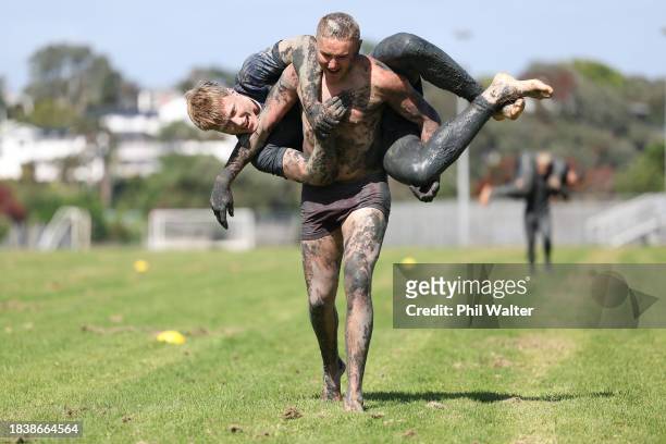 Tristyn Cook of the Blues holds Cam Christie during an Auckland Blues mud run training session at Devonport Naval Base on December 08, 2023 in...
