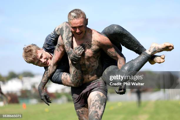 Tristyn Cook of the Blues holds Cam Christie during an Auckland Blues mud run training session at Devonport Naval Base on December 08, 2023 in...