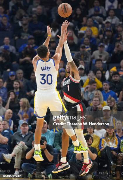 Stephen Curry of the Golden State Warriors shoots over Anfernee Simons of the Portland Trail Blazers during the first quarter of an NBA basketball...