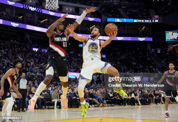 Stephen Curry of the Golden State Warriors shoots over Scoot Henderson of the Portland Trail Blazers during the fourth quarter at Chase Center on...