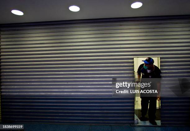 Worker of a pizza restaurant wears a surgical mask and prepares himself to close in precaution to ward off contagion with the new multi-strain swine...