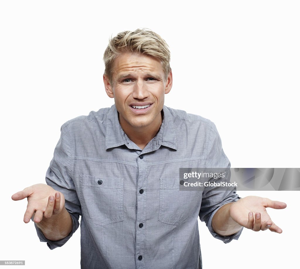Young man shrugging in surprise