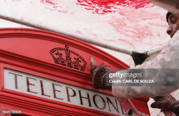 British red telephone box is repainted and in London, April 26, 2005. Even with mobile phone owned by most Londoners, the familiar red phone box...