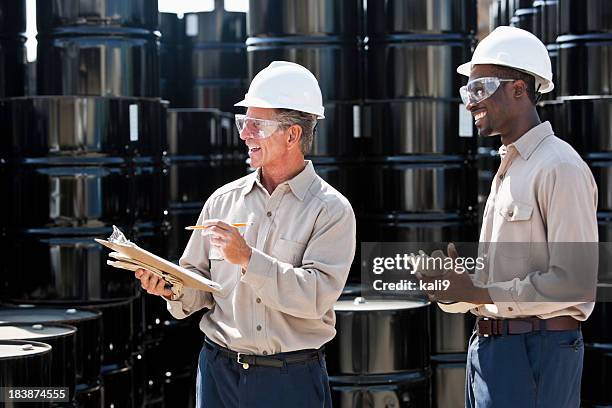 manufacturing workers by steel drums - drum container stock pictures, royalty-free photos & images