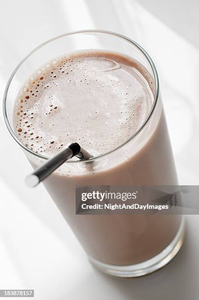 a chocolate milk in a clear glass with a straw - chocolate smoothie bildbanksfoton och bilder