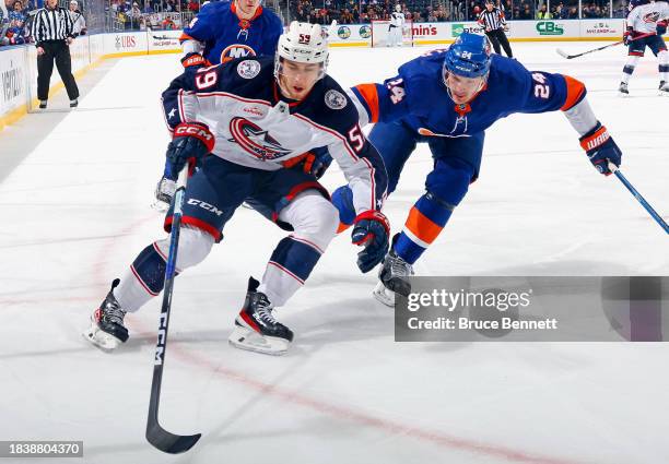 Yegor Chinakhov of the Columbus Blue Jackets attempts to skate around Scott Mayfield of the New York Islanders during the first period at UBS Arena...