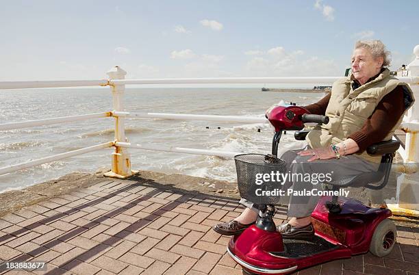 elderly lady by the sea - mobility scooters stock pictures, royalty-free photos & images