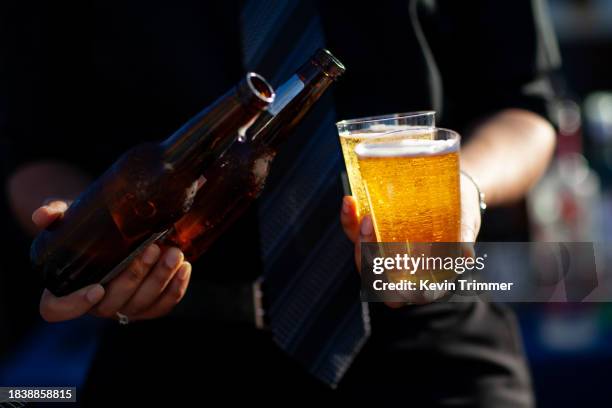 glowing beers carried in one hand - cerveza fotografías e imágenes de stock