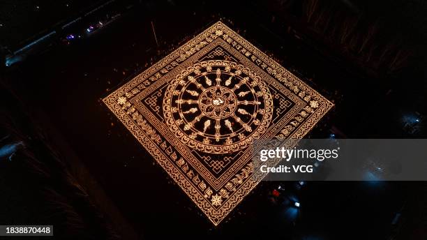 Aerial view of butter lamps lit on the square in front of the Puning Temple, also known as the Big Buddha Temple, at night to celebrate Butter Lamp...