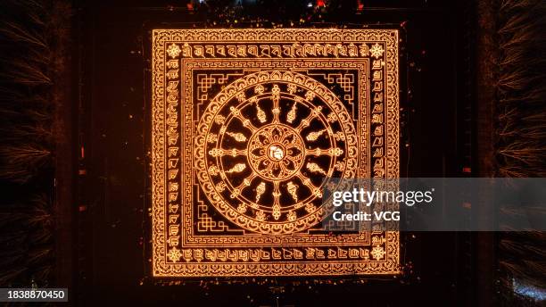 Aerial view of butter lamps lit on the square in front of the Puning Temple, also known as the Big Buddha Temple, at night to celebrate Butter Lamp...