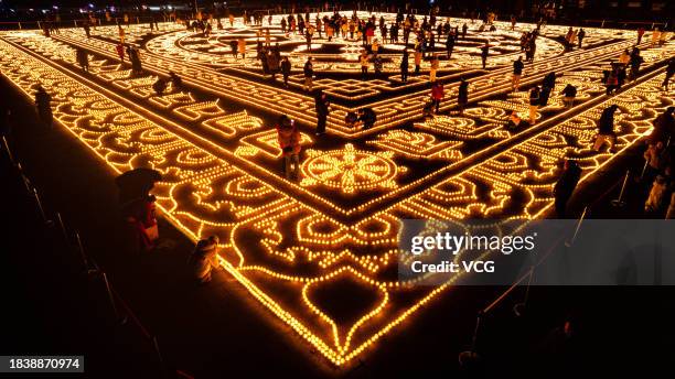 Aerial view of butter lamps lit on the square in front of the Puning Temple, also known as the Big Buddha Temple, at night to celebrate Butter Lamp...