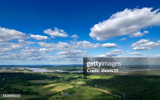 Green Arkansas landscape under a blue cloudy sky