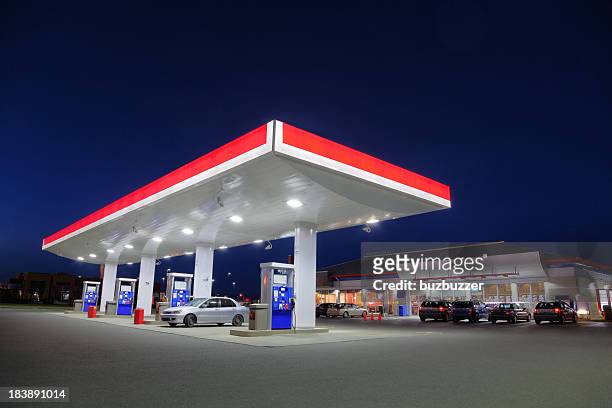 echar combustible coche en gasolinera durante la noche - garage fotografías e imágenes de stock