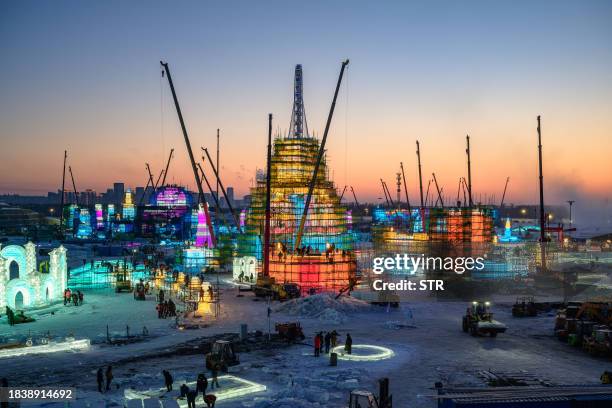 In this photo taken on December 10, 2023 workers build ice structures for the 25th Harbin Ice and Snow World in Harbin, in China's northern...