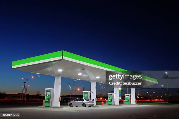 green gas station lights at night - benzinestation stockfoto's en -beelden