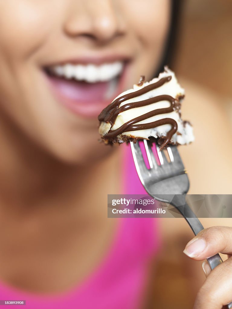 Latin woman eating a piece of cake