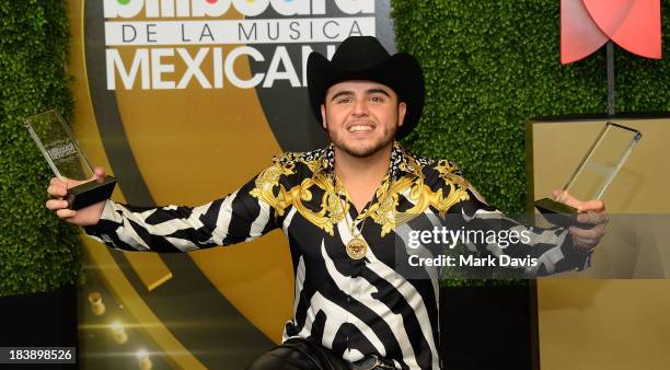 Singer Gerardo Ortiz poses in the pressroom with the awards for Male Artist of the year, Songs Artist of the year, Norteno Artist of the year and...