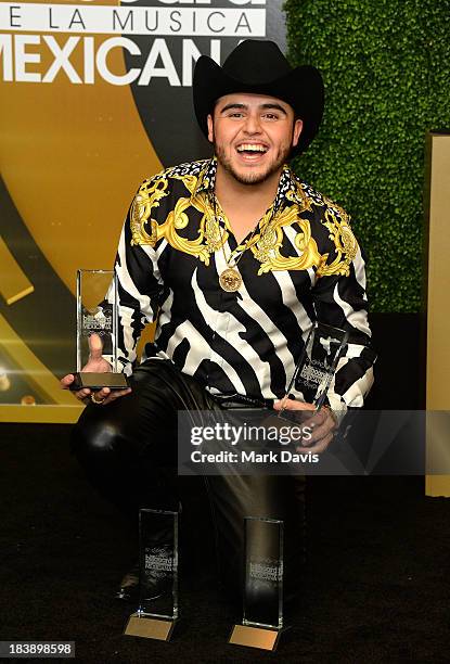 Singer Gerardo Ortiz poses in the pressroom with the awards for Male Artist of the year, Songs Artist of the year, Norteno Artist of the year and...