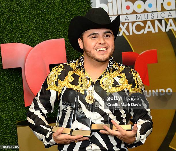 Singer Gerardo Ortiz poses in the pressroom with the awards for Male Artist of the year, Songs Artist of the year, Norteno Artist of the year and...