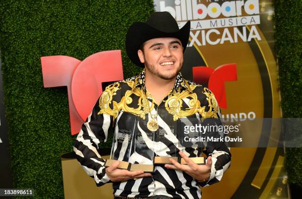 Singer Gerardo Ortiz poses in the pressroom with the awards for Male Artist of the year, Songs Artist of the year, Norteno Artist of the year and...