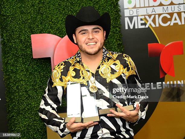 Singer Gerardo Ortiz poses in the pressroom with the awards for Male Artist of the year, Songs Artist of the year, Norteno Artist of the year and...