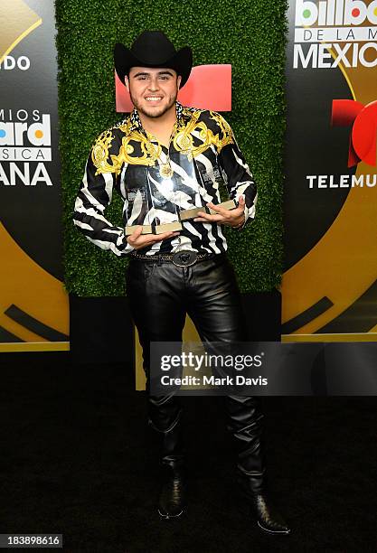 Singer Gerardo Ortiz poses in the pressroom with the awards for Male Artist of the year, Songs Artist of the year, Norteno Artist of the year and...